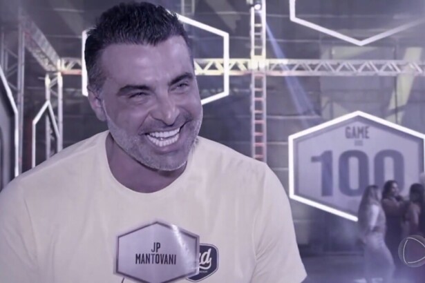 JP Mantovani sorrindo em registro preto e branco, nos bastidores do Game dos 100