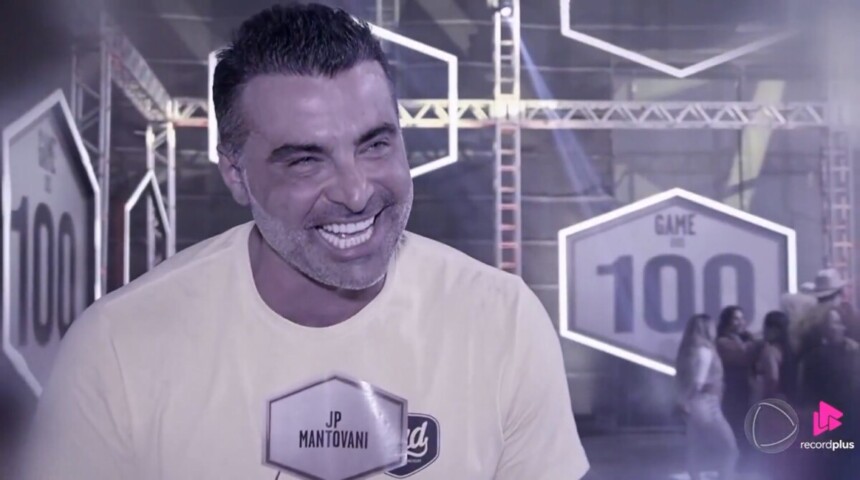 JP Mantovani sorrindo em registro preto e branco, nos bastidores do Game dos 100