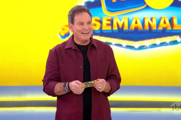 Luis Ricardo sorridente em frente ao telão da Tele Sena Semanal amarelo