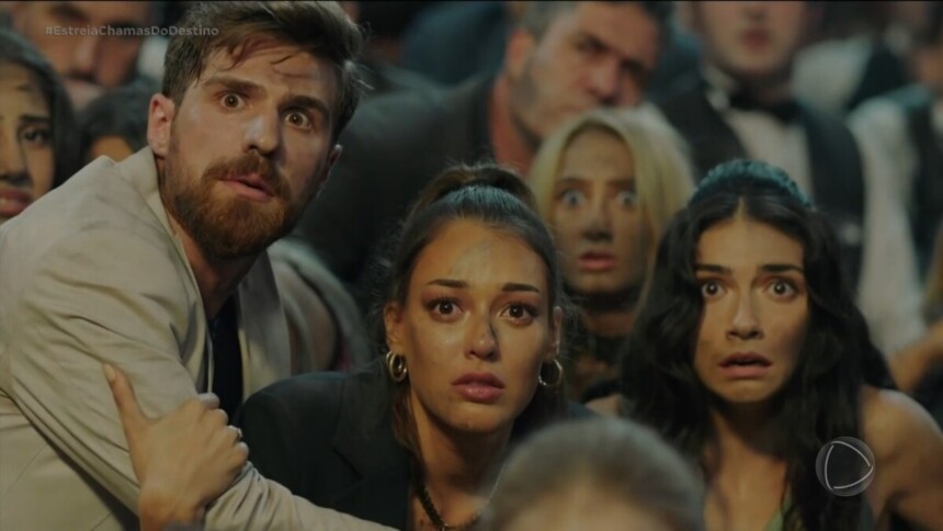 Protagonistas da novela Chamas do Destino olham assustados para uma grande chama no incêndio do primeiro capítulo da novela